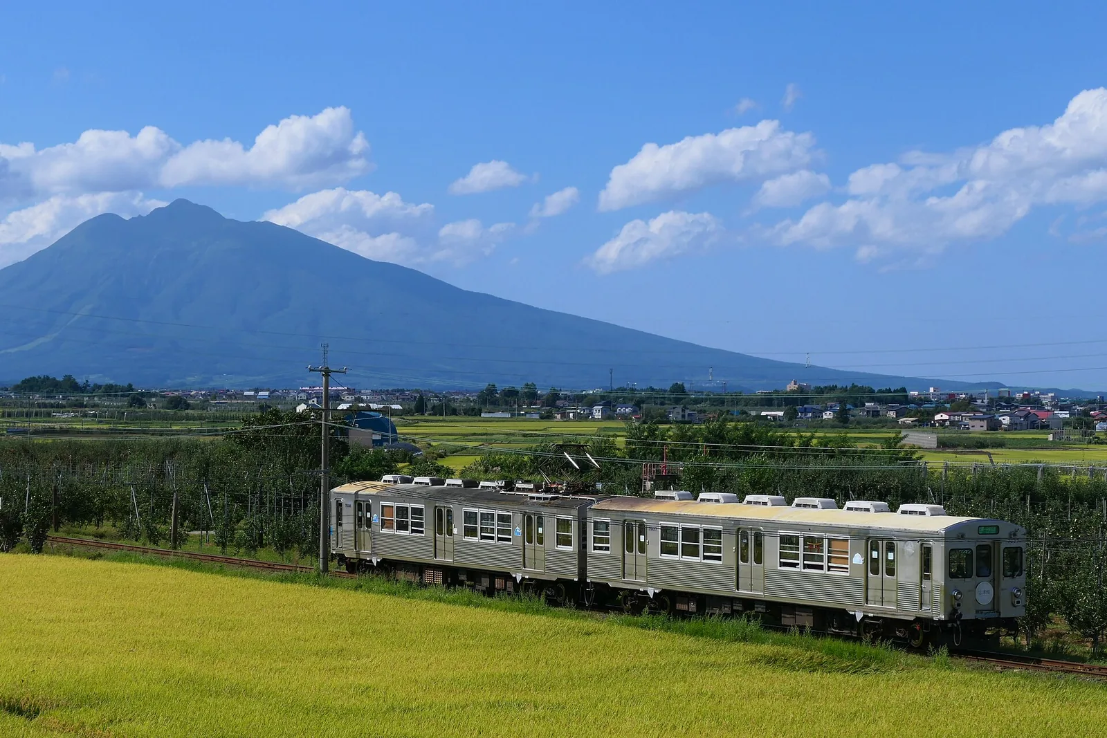 岩木山下行駛的弘南鐵道大鰐線 7000 系列車